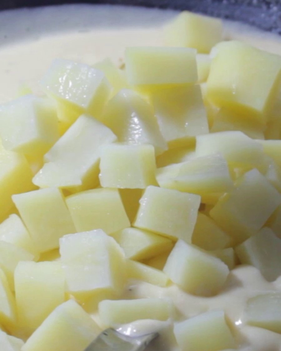 Diced potatoes going into the cream base