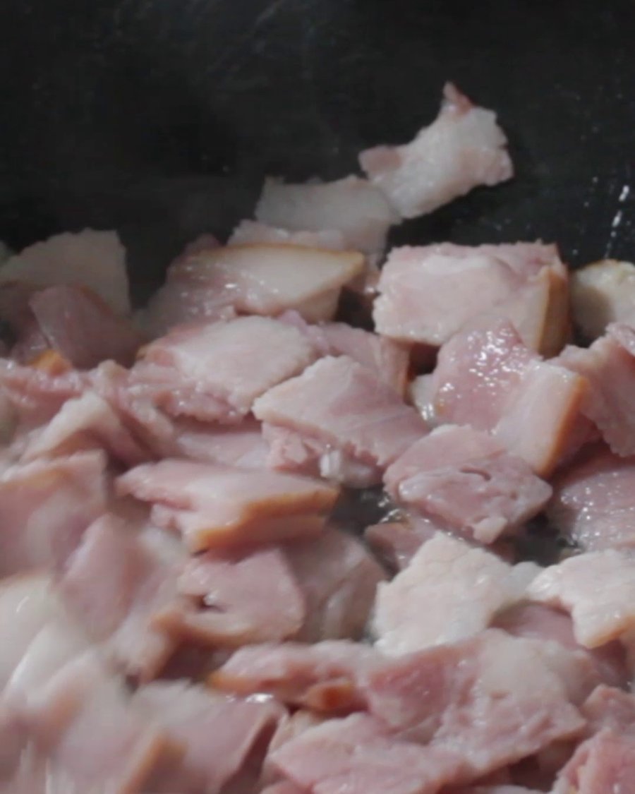 Searing diced ham in a pan